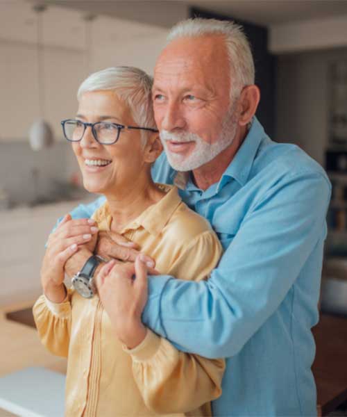 An older couple smiling together at home
